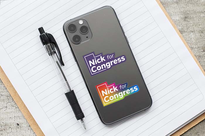 Phone with two Nick for Congress stickers; one is purple, the other is rainbow