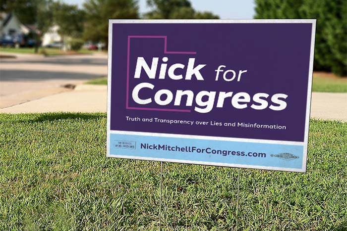 Purple yard sign in grass with the text 'Nick for Congress'