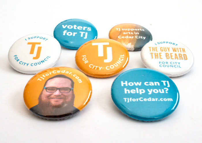 Seven button designs used for the campaign, all in the white, gold, and turquoise color scheme