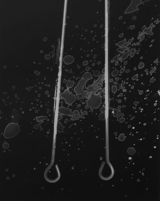 Photogram of two rods with splatters
