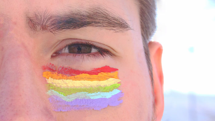 Image of an eye with a rainbow painted beneath it