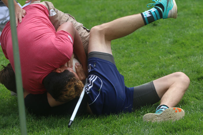 Two men fight on the ground over a ball