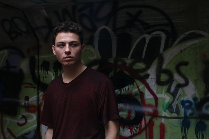 Rapper standing in graffiti-filled tunnels