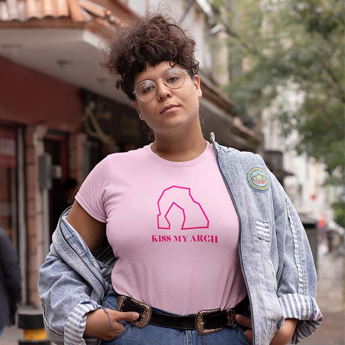 Woman wearing a pink shirt that says 'Kiss my Arch' with an icon of Delicate Arch