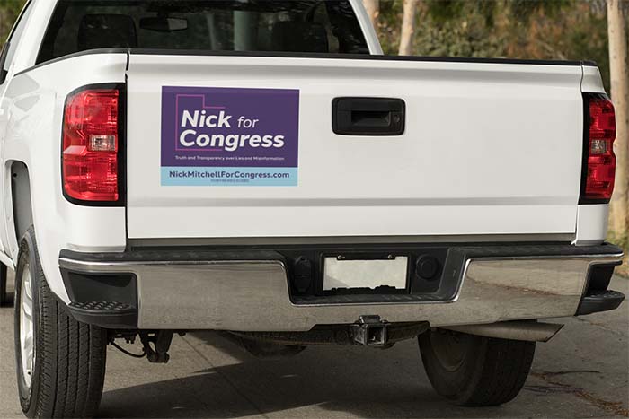 Image of the back of a truck with a purple 'Nick for Congress' sticker