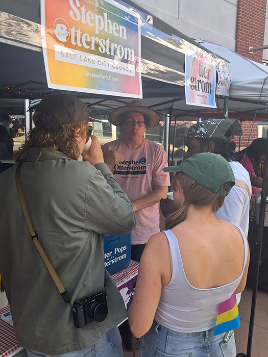 Man in pink shirt talking to two people
