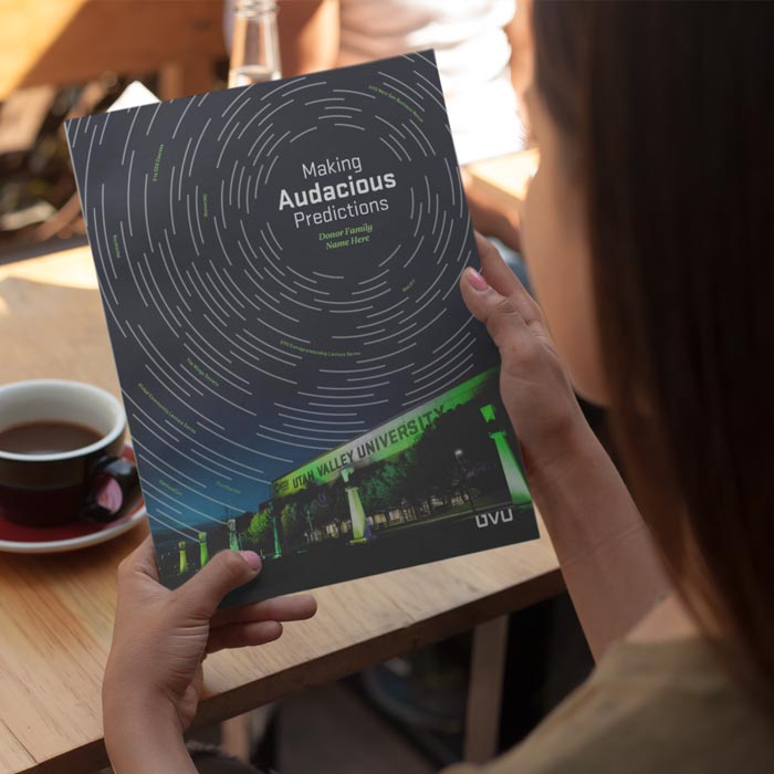 Person holding a proposal with a university builiding and star trails on it