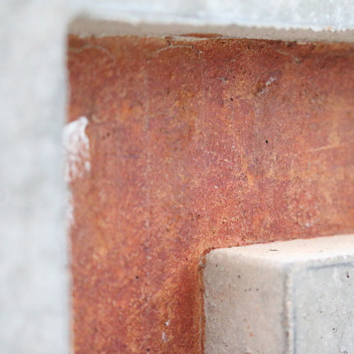 Detail shot of orange lettering inset into a concrete wall